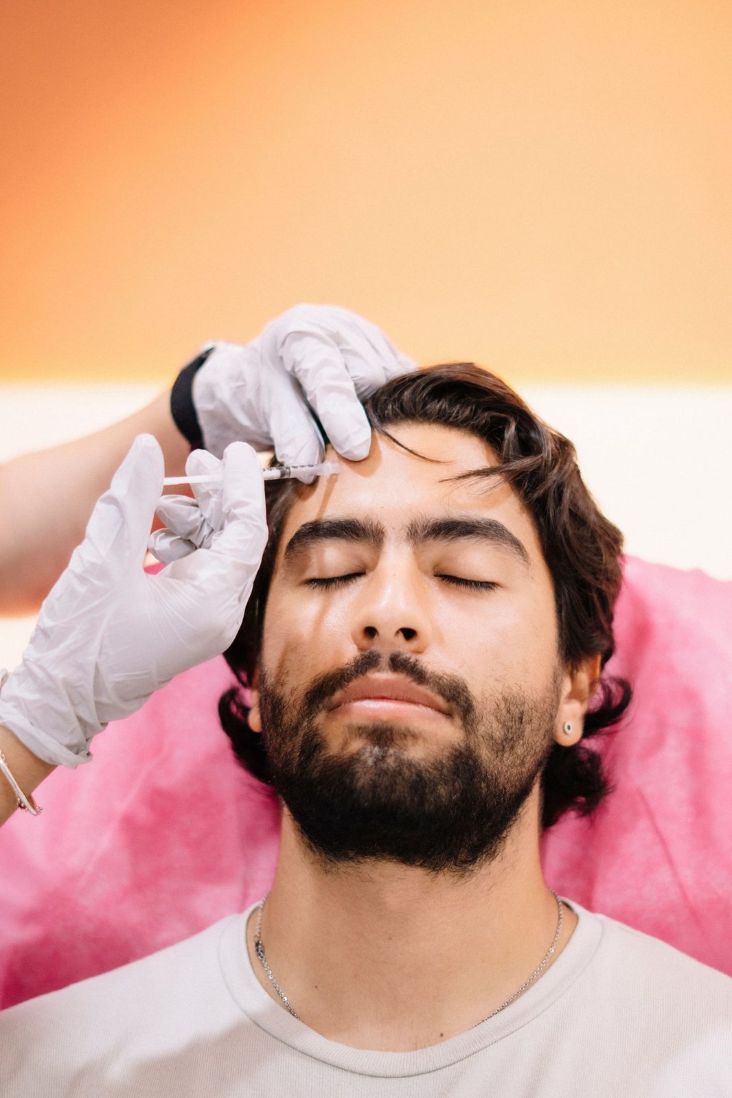 Homem recebendo procedimento estético facial em ambiente clínico