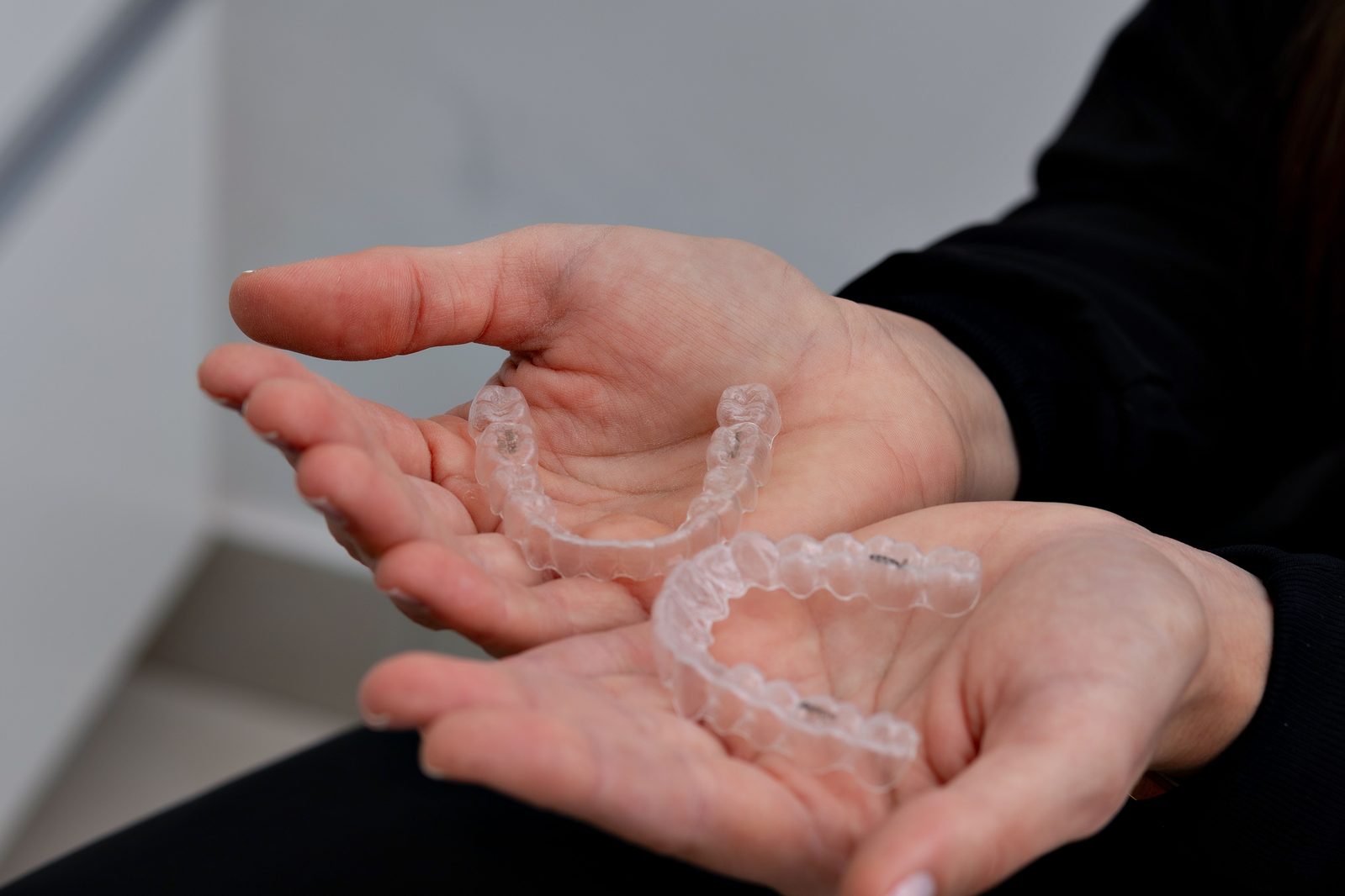 Duas placas de alinhador transparente seguradas na mão